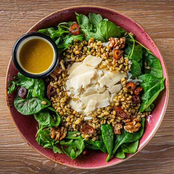 Zazzy's Lebanese salad with grains, spinach, walnuts, dates, parmesan, and dressing.