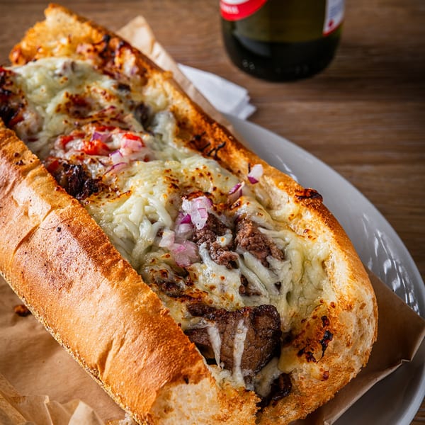 Zazzy's Lebanese-style cheesesteak, a toasted baguette filled with meat, melted cheese, and red onions.